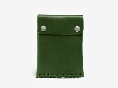 A green leather pouch with a flap secured by two silver snap buttons. The pouch has visible stitching at the bottom and a debossed logo in the lower right corner. The background is plain white.