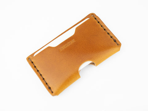 A sleek tan cordovan leather wallet with visible stitching along the edges, an open slot for cards or cash, and the embossed brand name BILLYKIRK on the front, photographed on a white background.