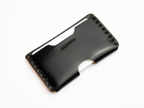 A sleek black cordovan leather wallet with visible stitching along the edges, an open slot for cards or cash, and the embossed brand name BILLYKIRK on the front, photographed on a white background.