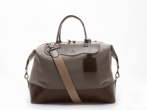 Beige and olive carryall  bag with a tan strap on a white background