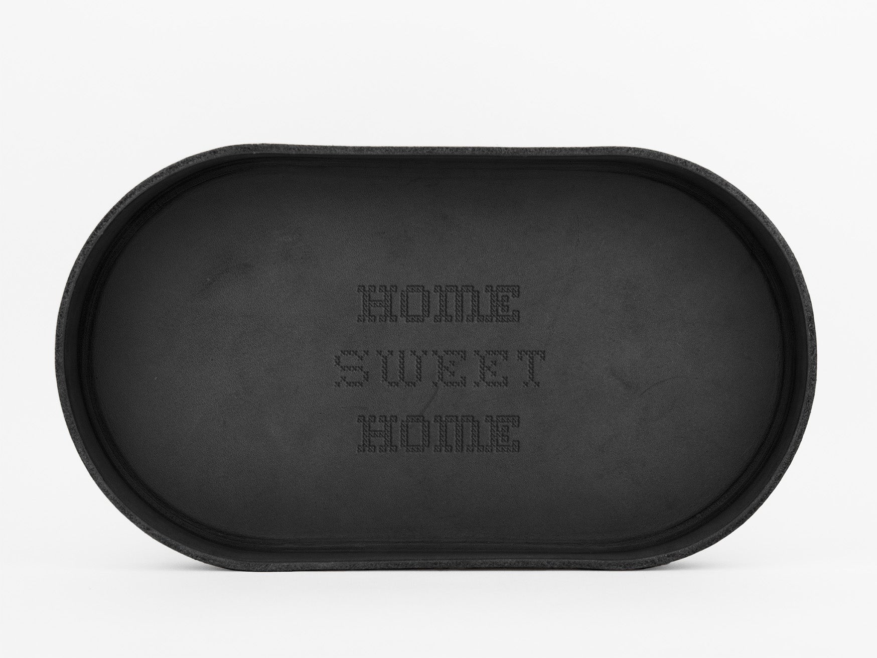 A black oval tray with the words HOME SWEET HOME written in a dotted pattern in the center. The background is white.