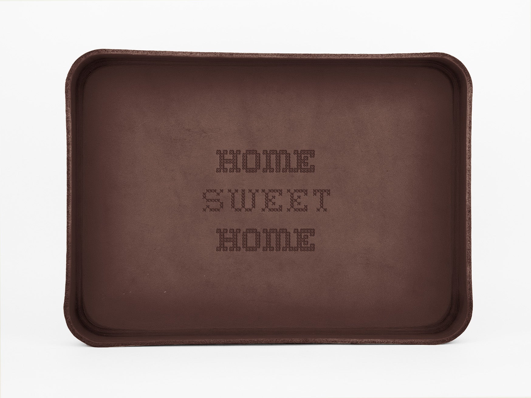 A brown rectangular baking tray with the words HOME SWEET HOME written in a pixelated, cross-stitch style in the center. The tray is placed against a plain white background.