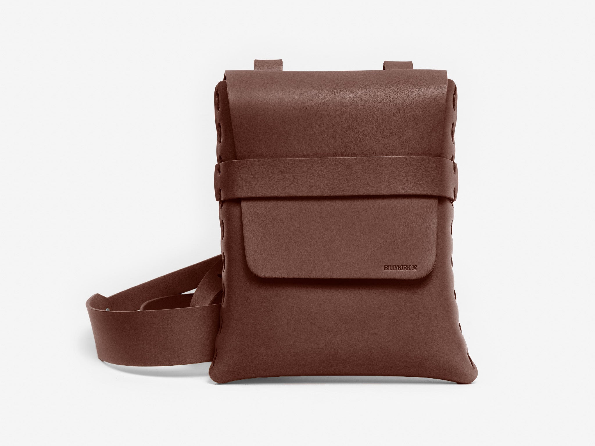 A brown leather crossbody bag with a flap closure, a front pocket, stitched edges, and an adjustable strap, displayed against a plain white background.