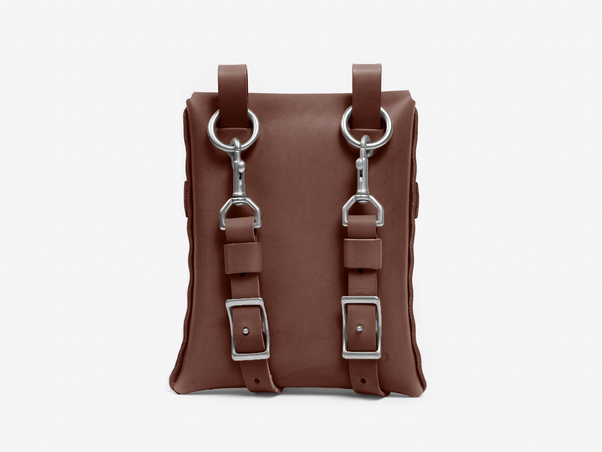 A brown leather bag with two silver buckles and metal rings attached to the front, against a plain white background.