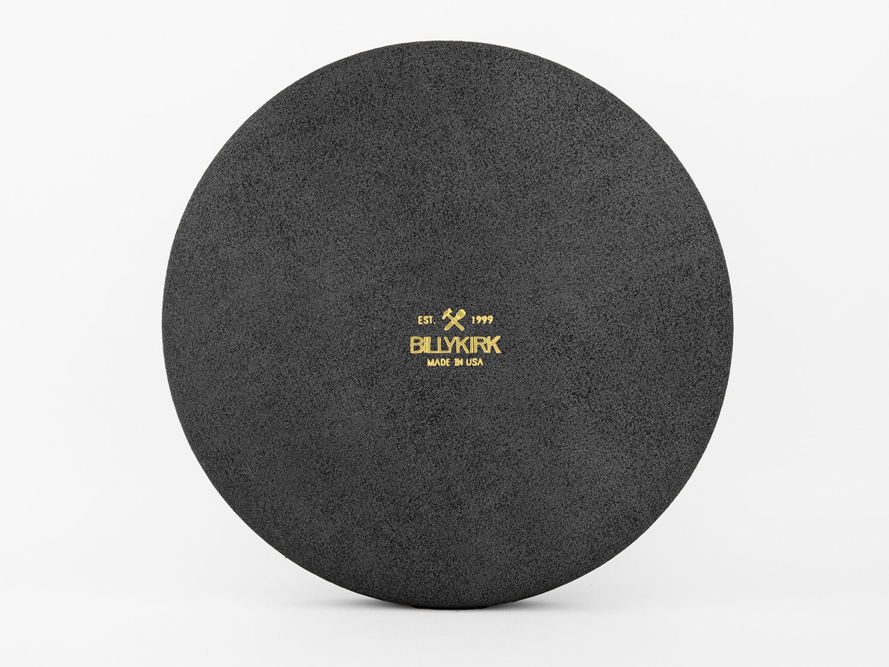 A round, black textured surface with the gold text BLKINKK, two small tools, EST 1999, and MADE IN USA printed in the center against a plain white background.