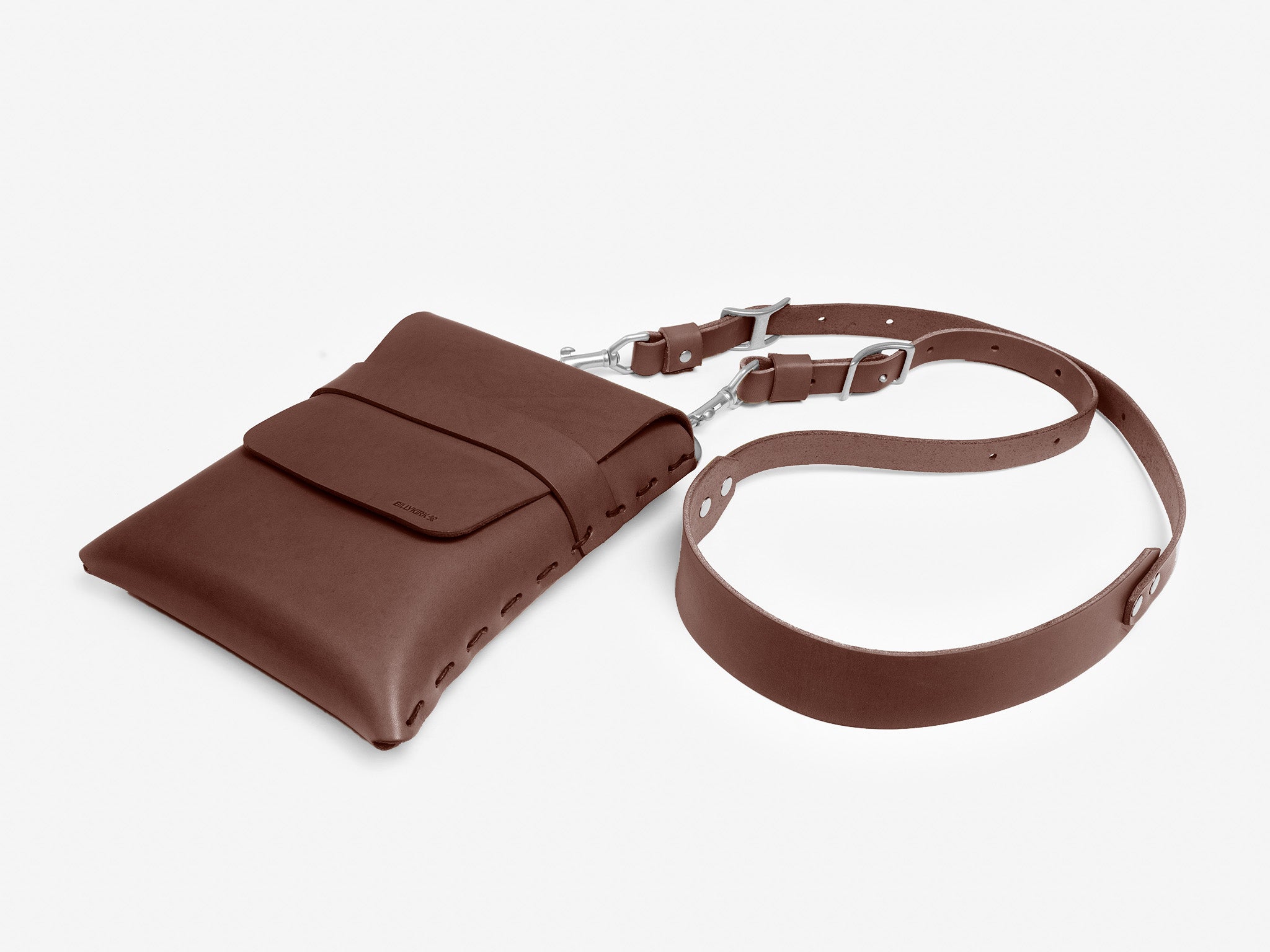 A brown leather crossbody bag with a front flap, stitched edges, and an adjustable strap, displayed on a white background.