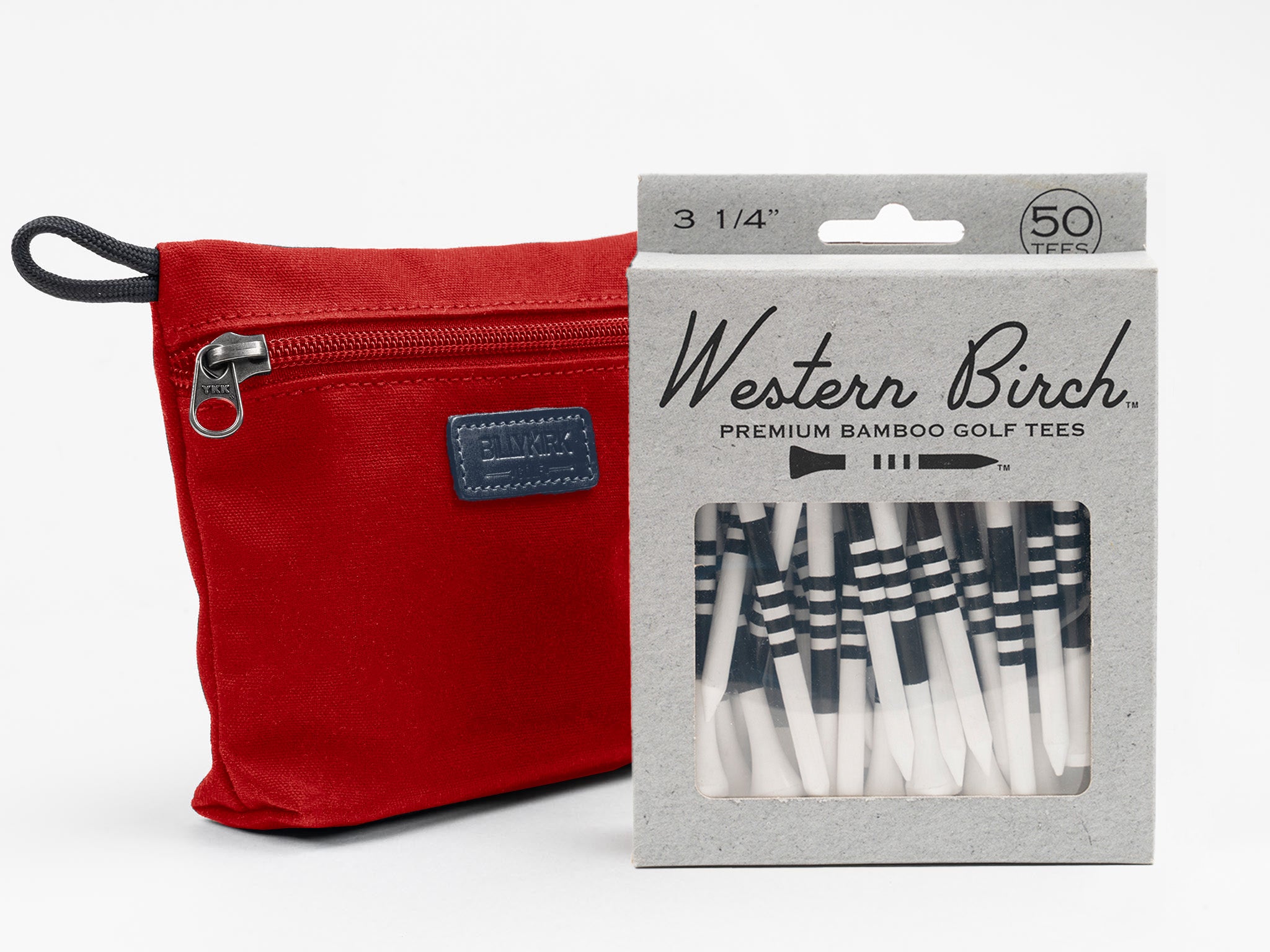 A red zippered pouch sits next to a box labeled Western Birch Premium Bamboo Golf Tees, containing 50 black-and-white striped golf tees visible through a clear window.
