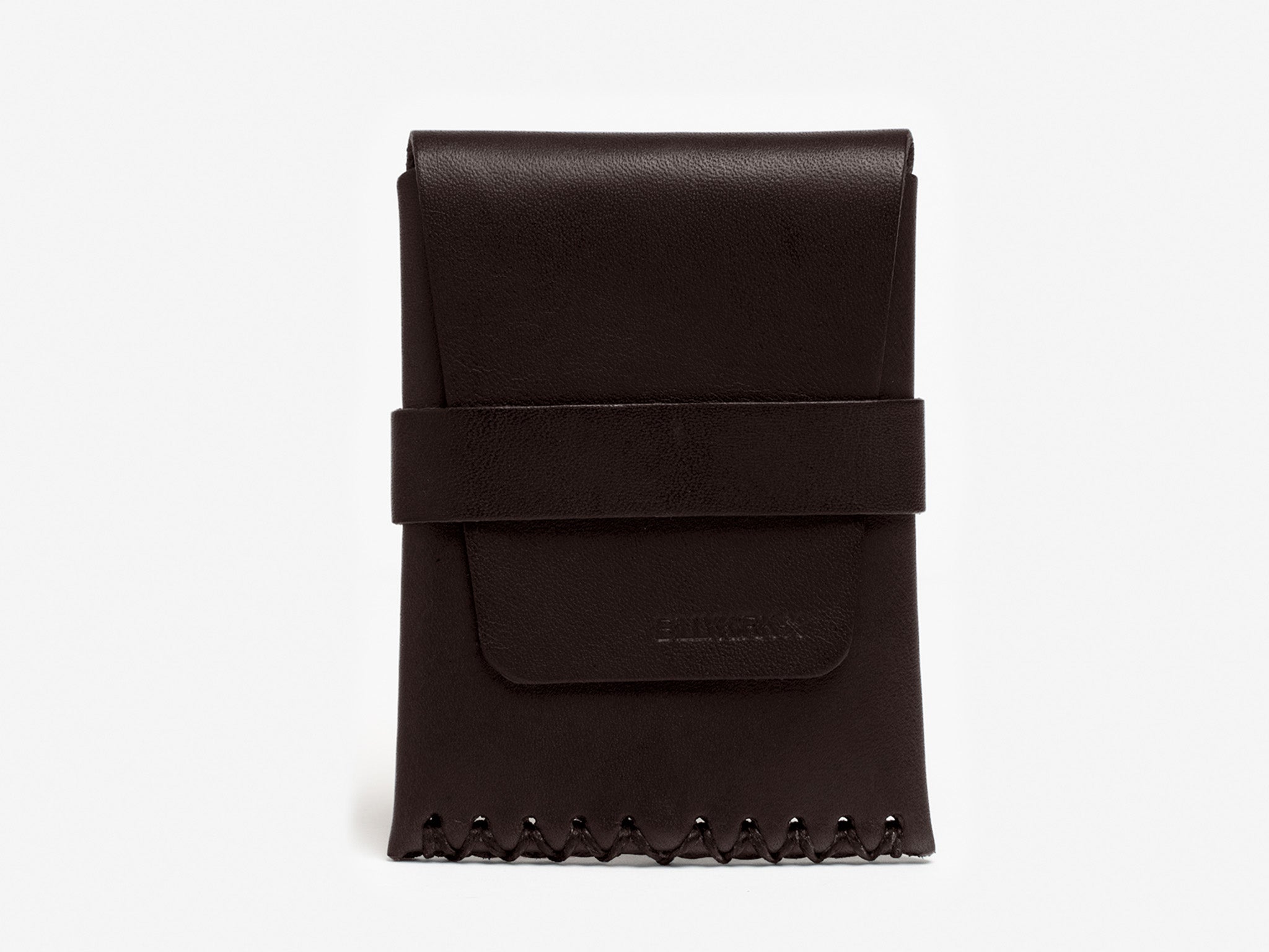 A brown leather card case with flap, hand-stitched, with visible waxed cording and a loop closure.