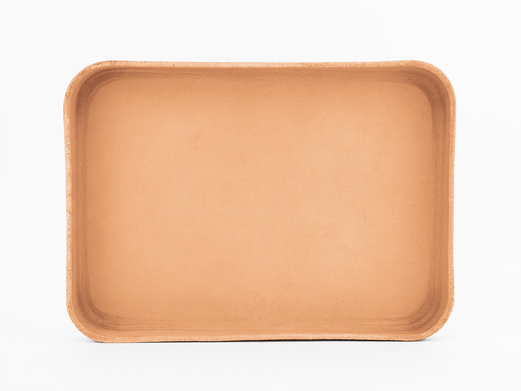 A rectangular, shallow, light brown tray with rounded corners, made from a natural material, is shown on a plain white background. The tray appears empty and has slightly raised edges.