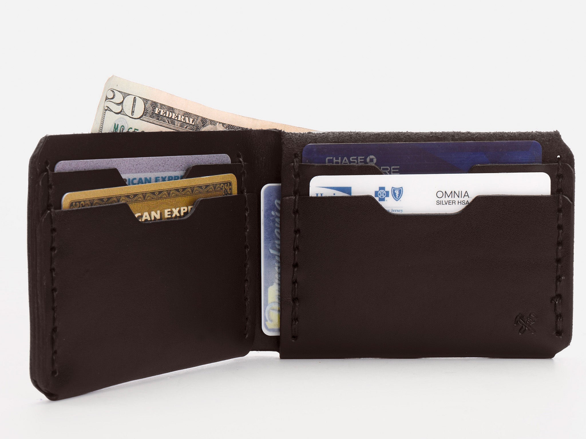 A black leather wallet is open, displaying a $20 bill and several credit and ID cards neatly organized in its slots against a white background.