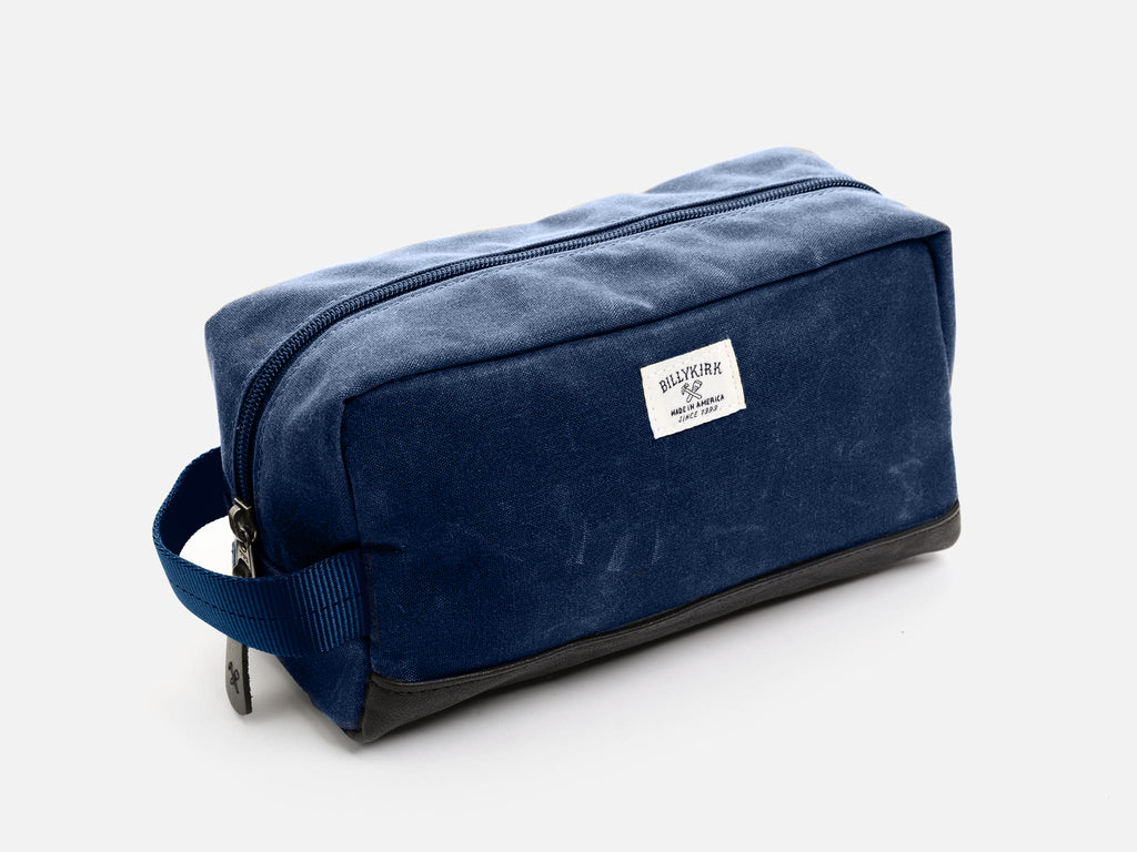 Blue toiletry bag with a visible brand label on a white background