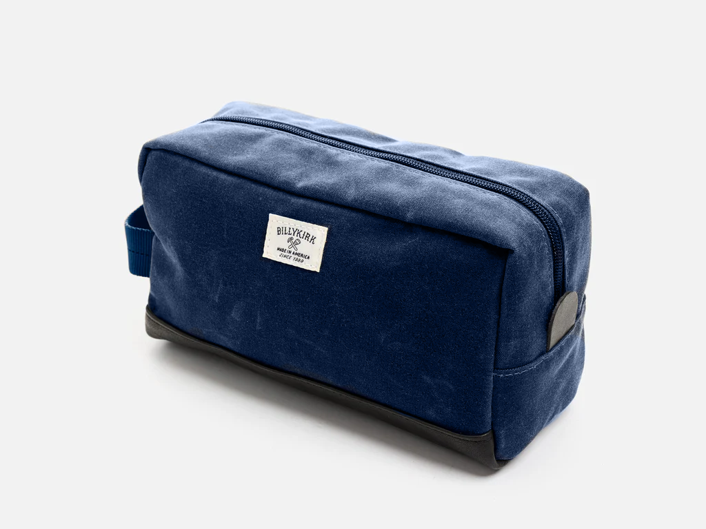 Blue toiletry bag with a visible brand label on a light gray background