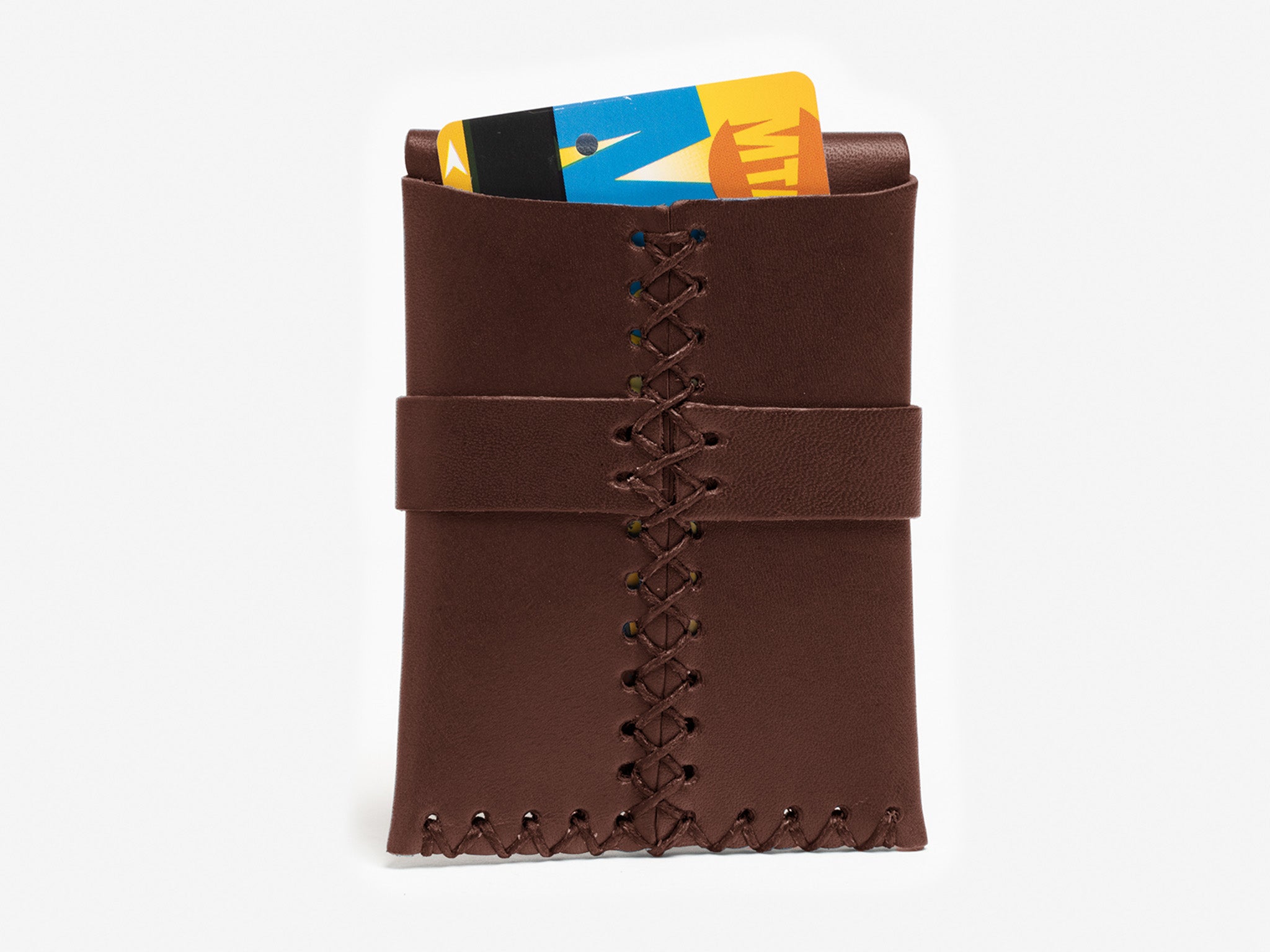 A brown leather card holder with visible stitching, holding two colorful cards, one partially visible at the top. The background is plain white.