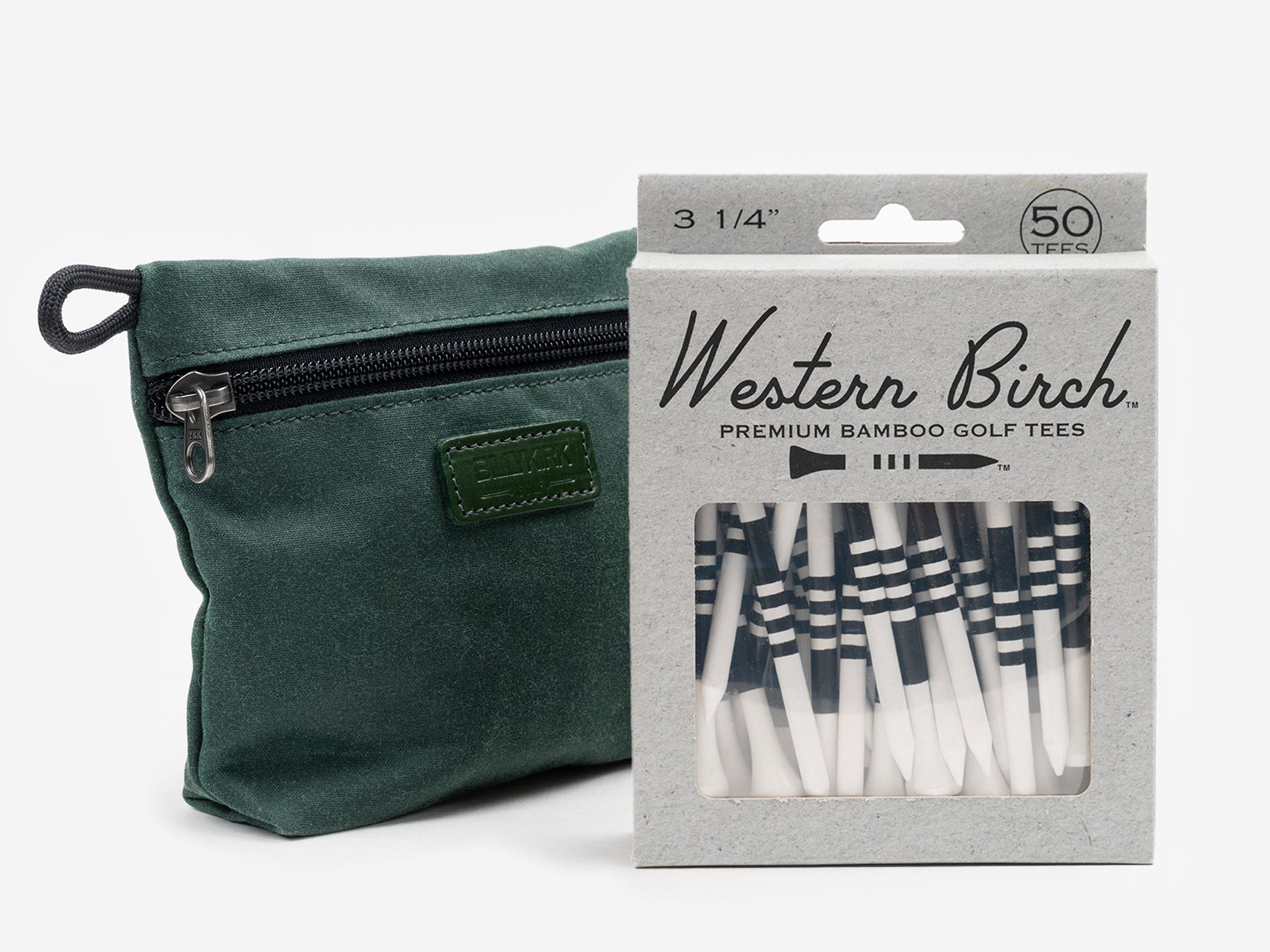 A green zippered pouch sits next to a box of Western Birch premium bamboo golf tees, with 50 black and white striped tees visible through the packaging window.
