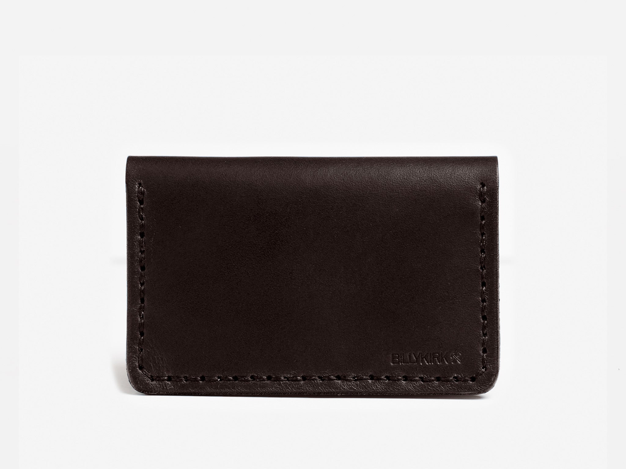 A simple, dark brown leather card holder with visible stitching along the edges, set against a plain white background. The brand name BILLYKIRK is embossed in small letters in the bottom right corner.