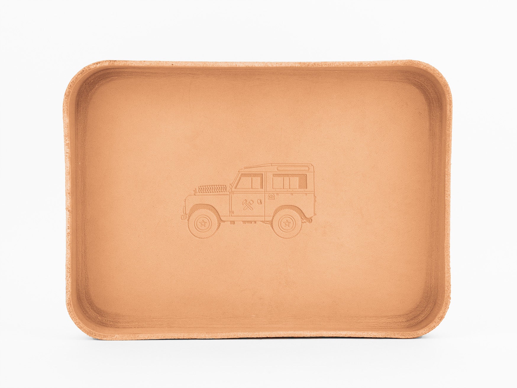 A rectangular tan tray with rounded corners, featuring an engraved outline of a classic off-road vehicle in the center. The tray is placed against a plain white background.