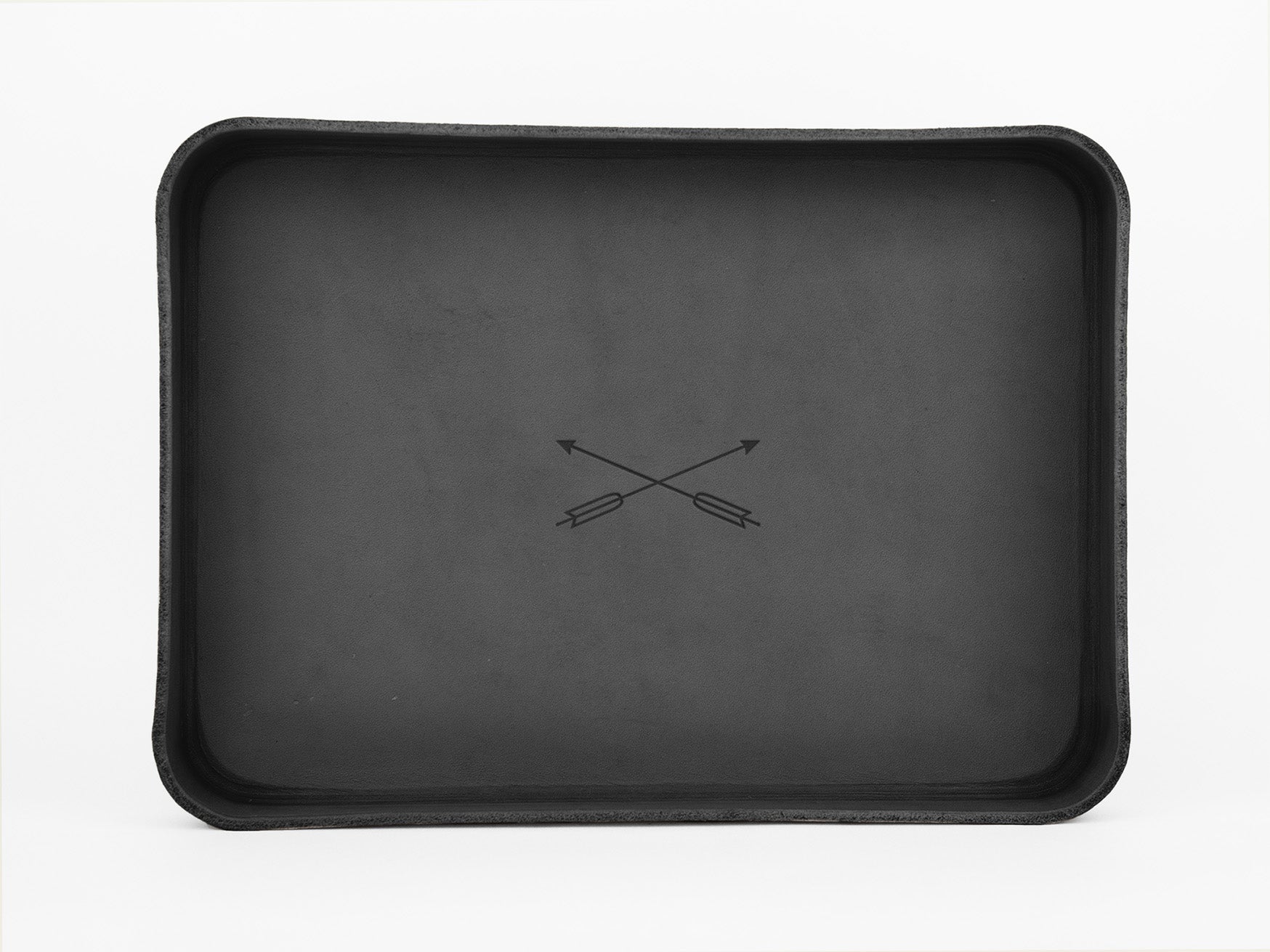 A rectangular, black tray with slightly raised edges features two crossed arrows in the center, set against a plain white background.