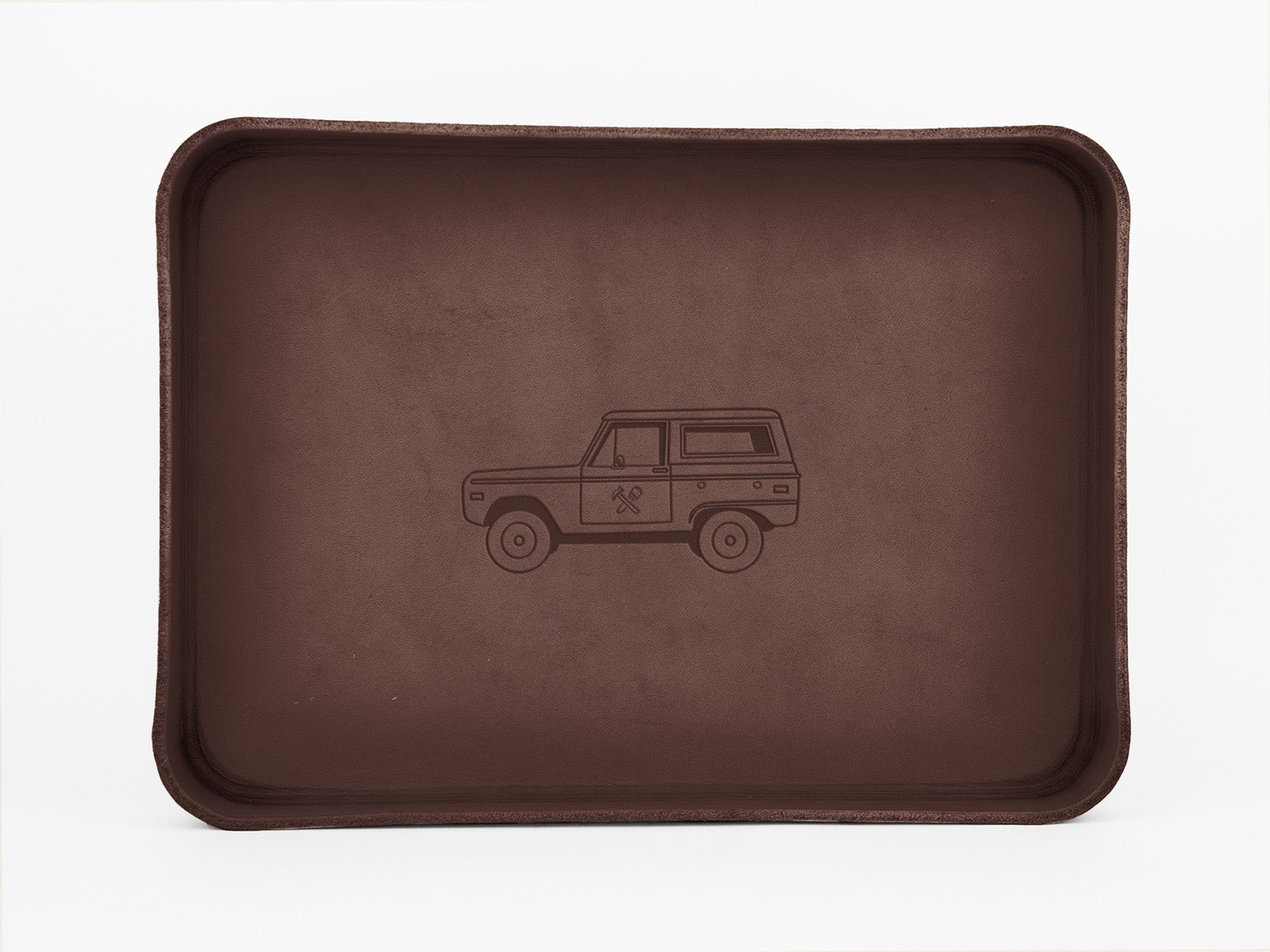 A brown rectangular tray with raised edges features a simple illustration of a vintage SUV on its flat surface.