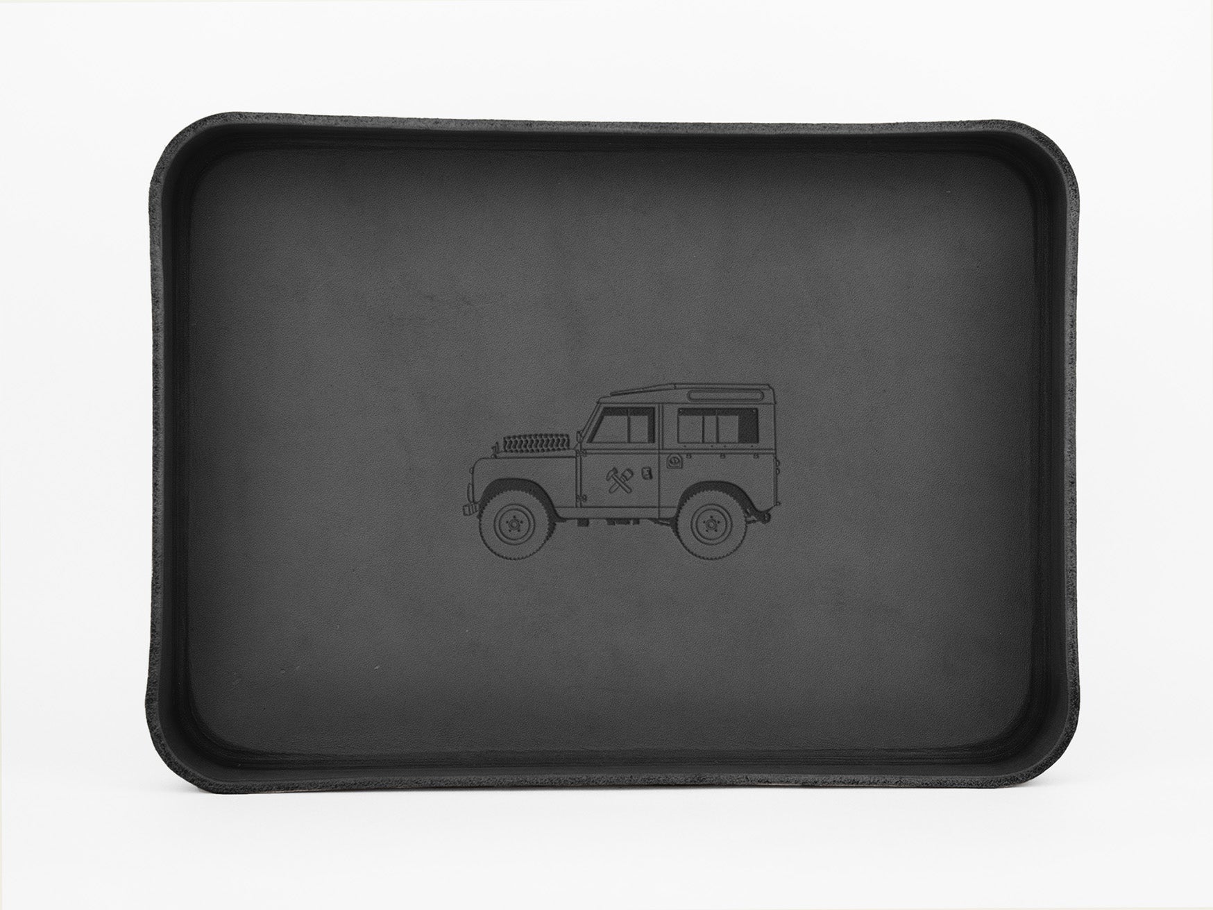 A black rectangular tray with raised edges features a simple outline drawing of an off-road vehicle in the center, set against a plain white background.