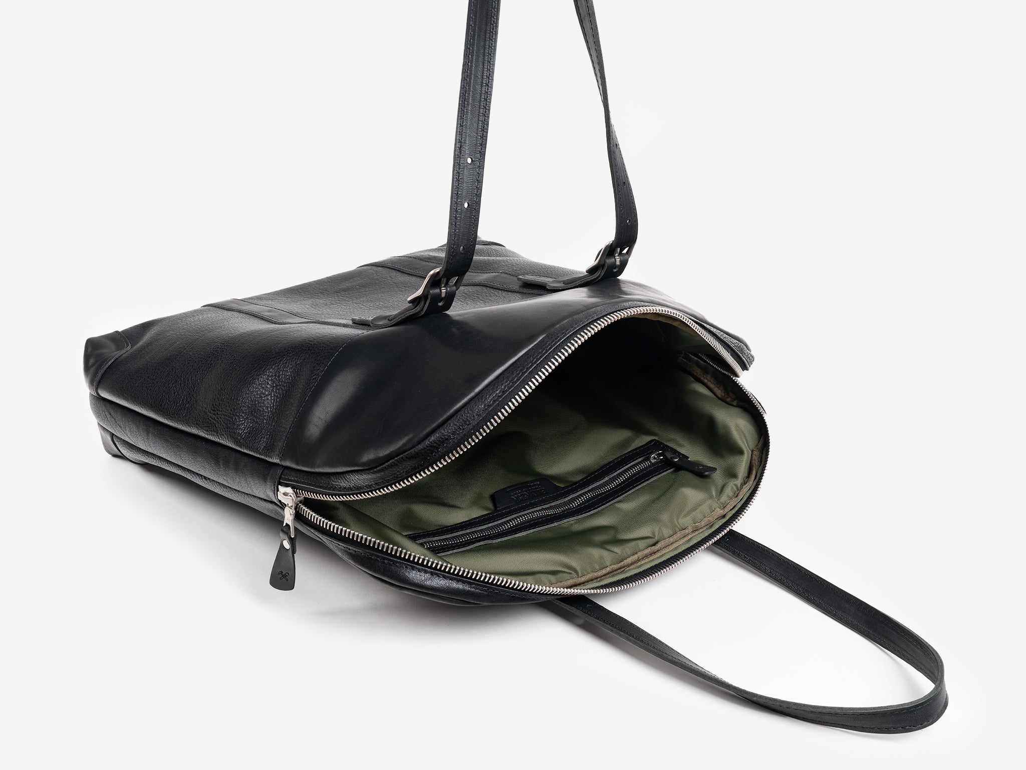 A black leather shoulder bag with silver zipper, partially open to reveal an olive green fabric interior and an inside zippered pocket, sitting on a white background.