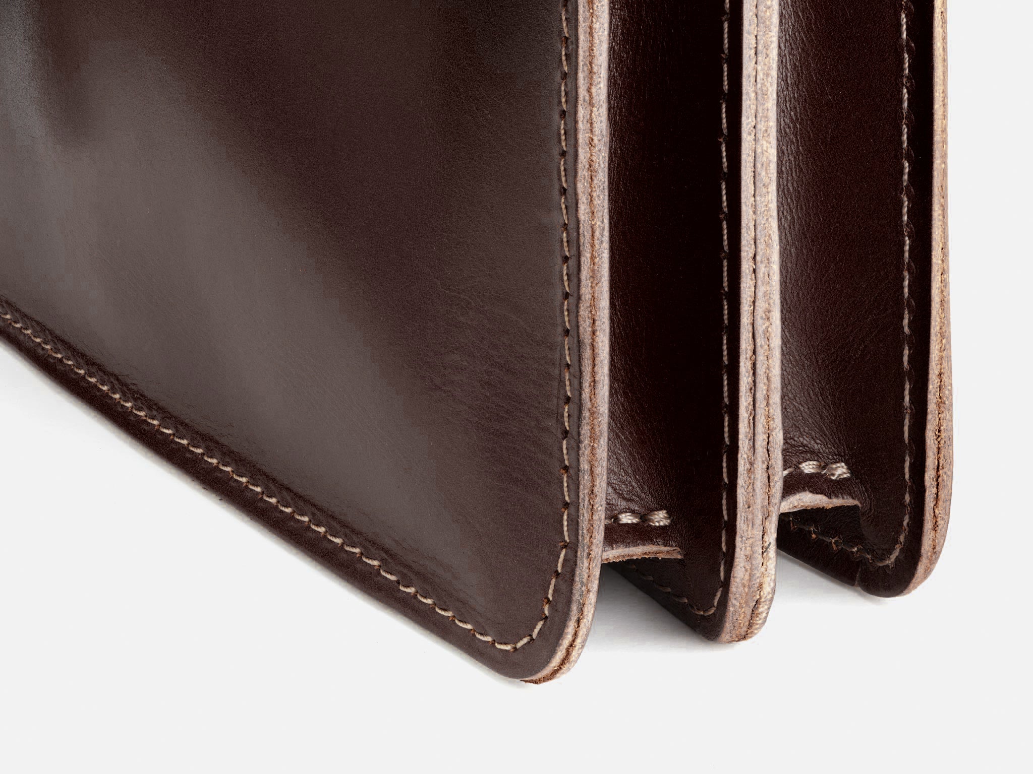 Close-up of a brown leather wallet showing its stitching and two interior compartments against a plain light background.