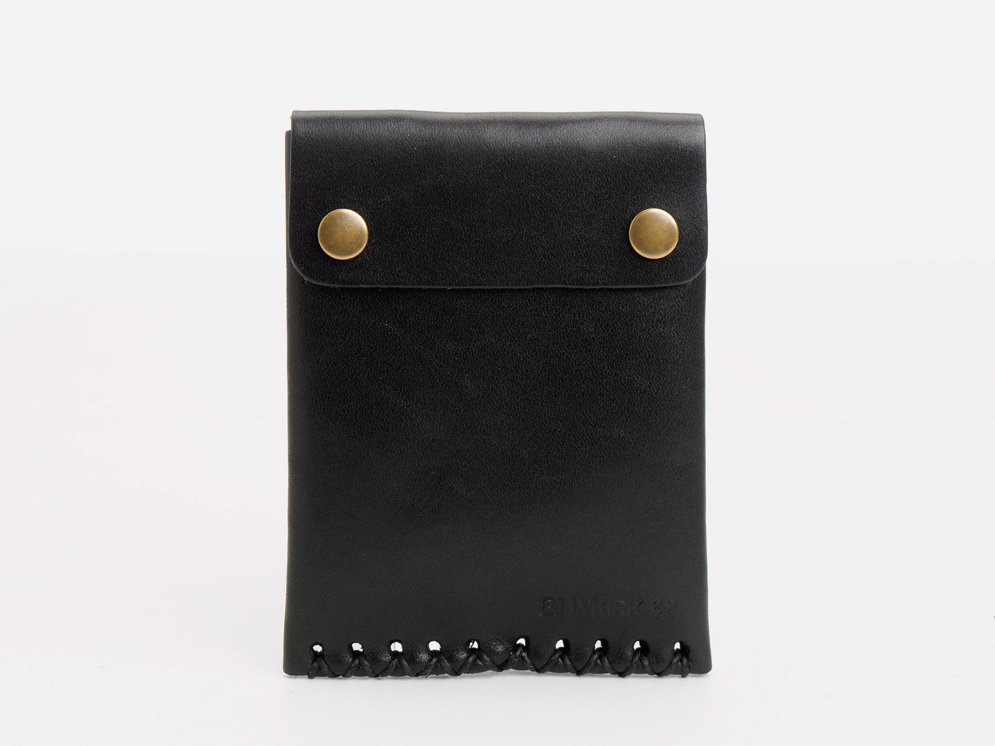 A black leather pouch with two brass snap buttons on the flap and crisscross stitching along the bottom edge, standing upright against a plain white background.