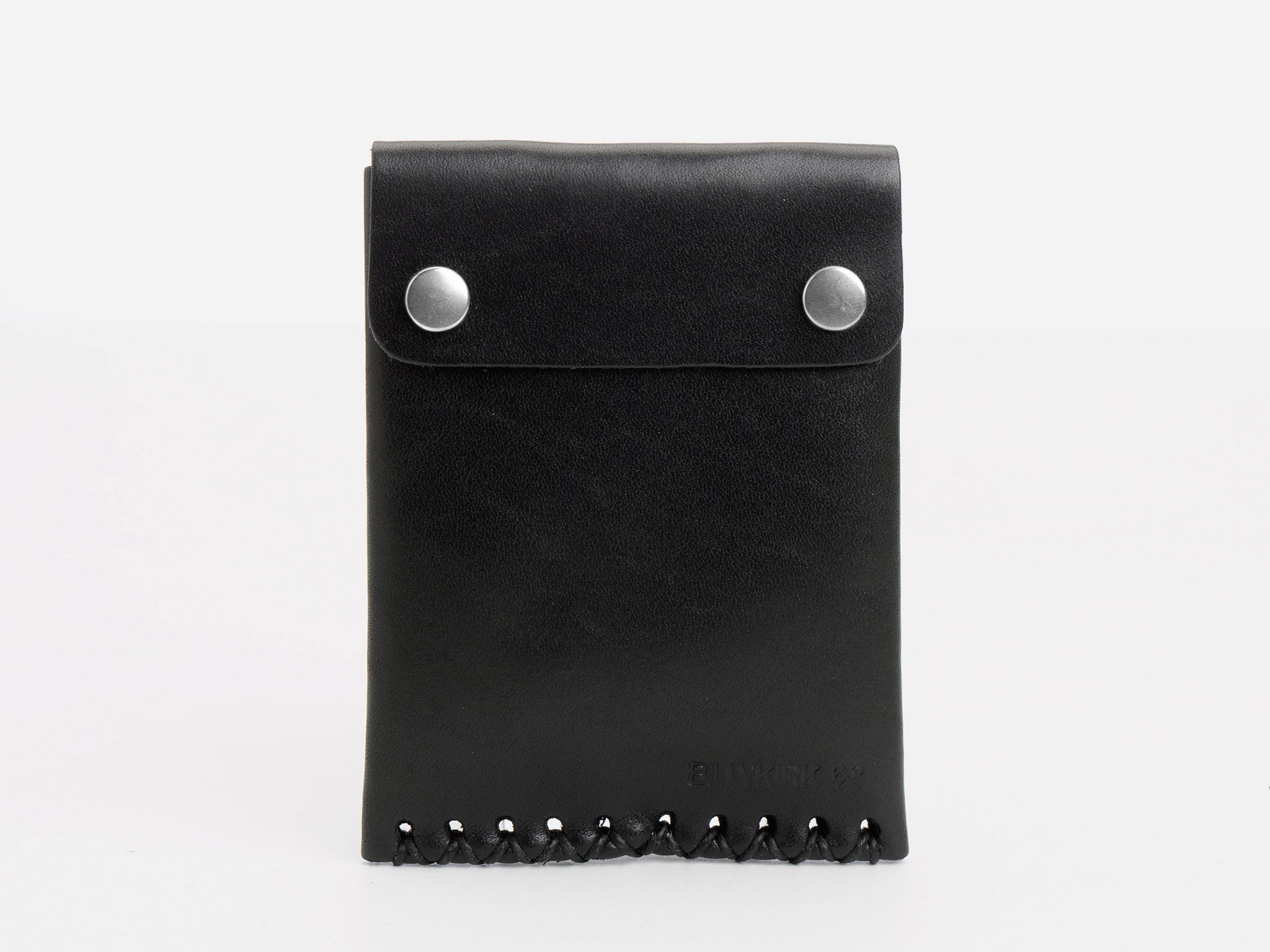 A black leather wallet with two silver snap buttons on the flap and decorative stitching along the bottom edge, standing upright against a plain white background.