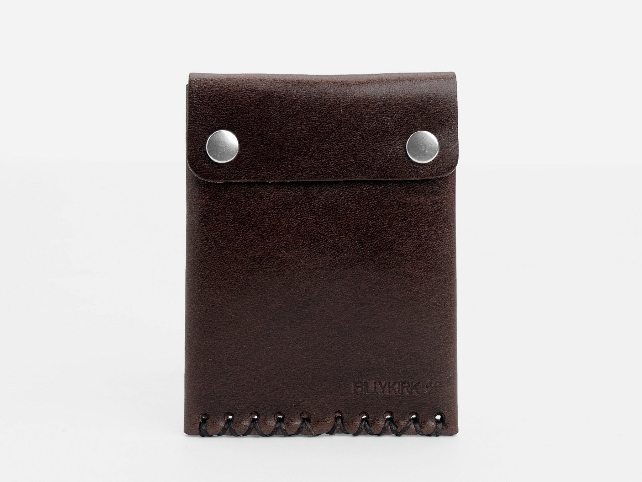 A dark brown leather wallet with two silver snap buttons on the flap and decorative stitching along the bottom edge, standing upright against a plain white background.