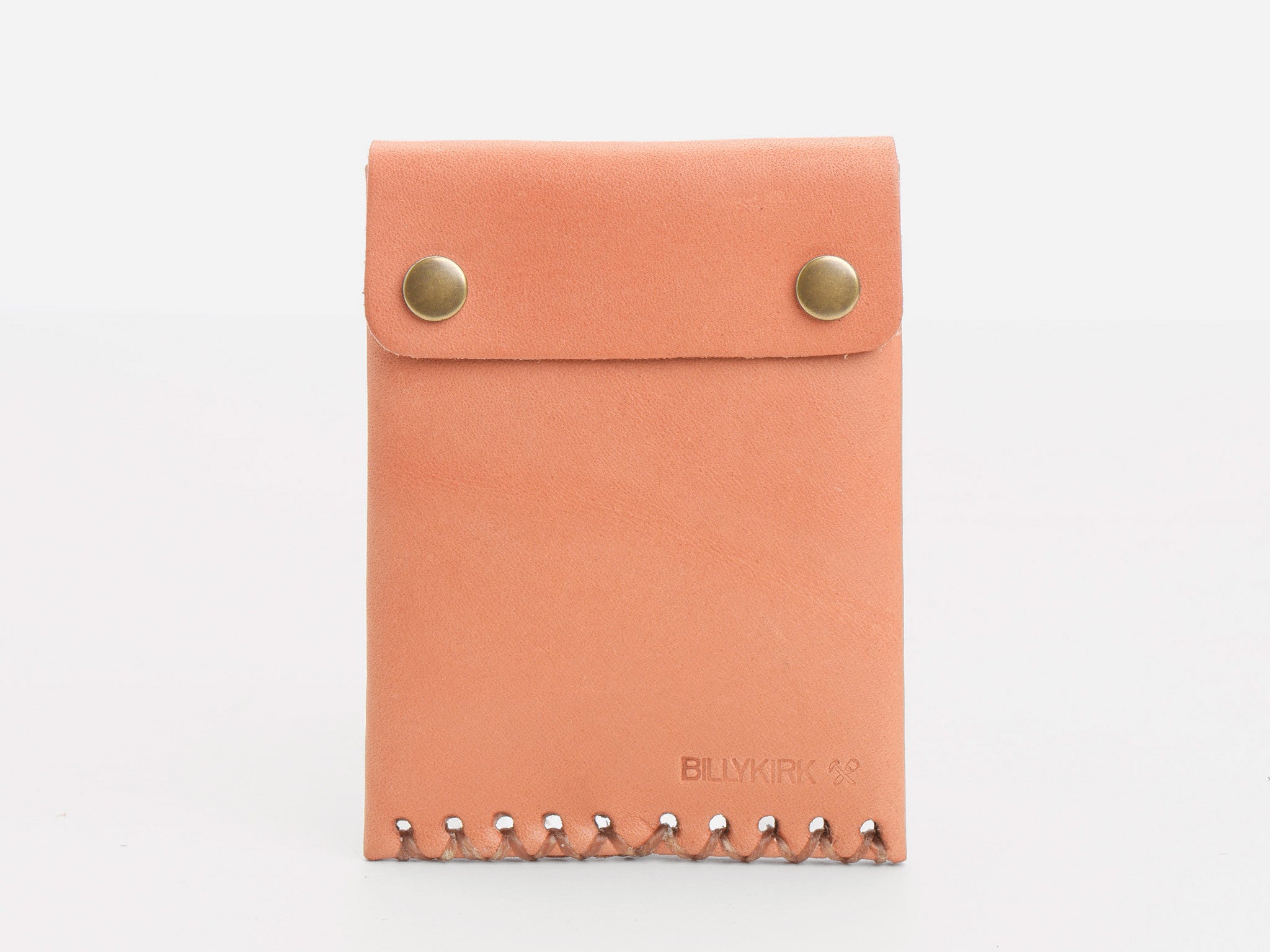 A light brown leather wallet with two brass snap buttons and decorative stitching at the bottom. The brand name BILLYKIRK is embossed in the lower right corner.