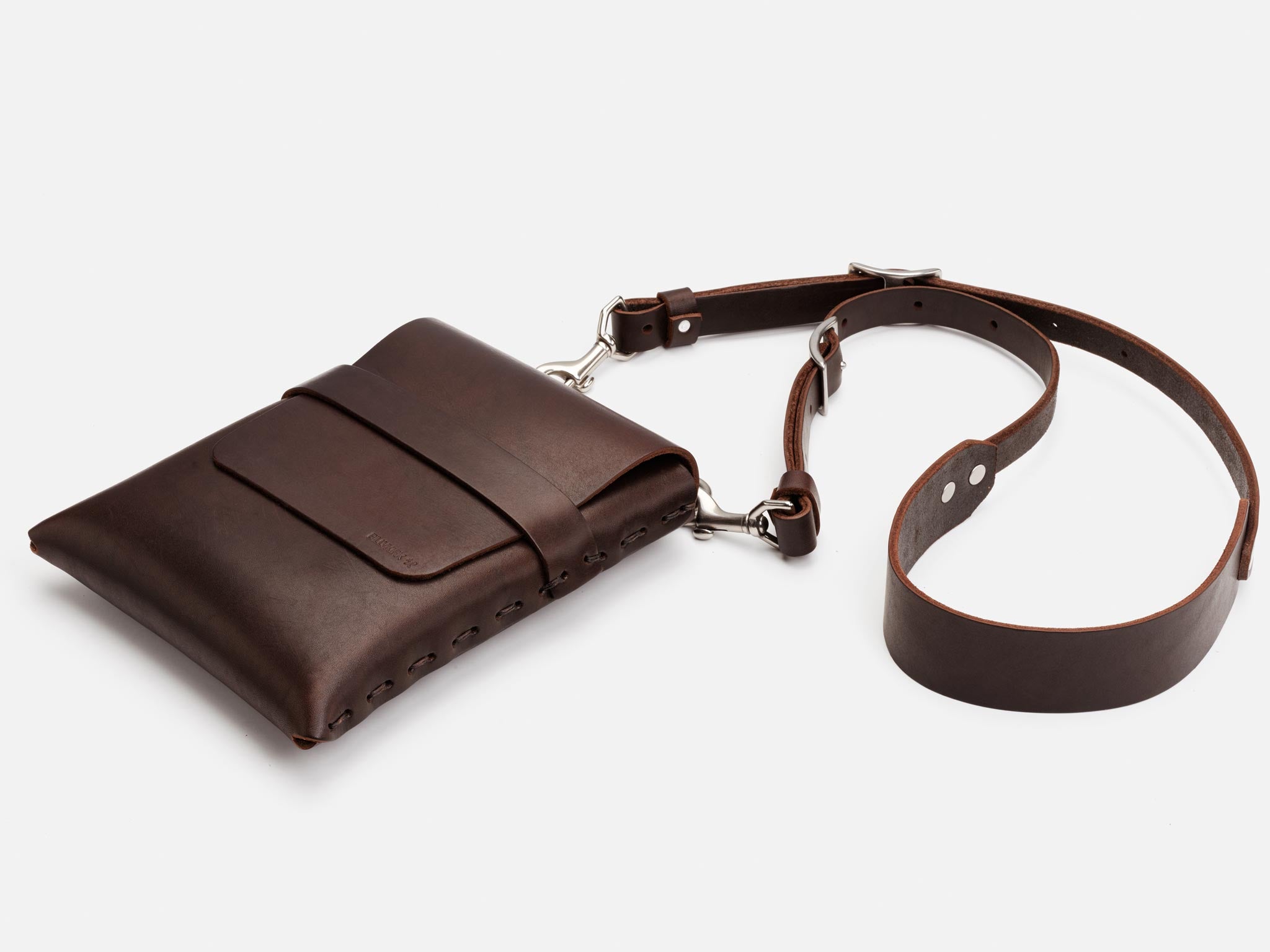A dark brown leather crossbody bag with a front pocket and a long, adjustable strap, displayed against a white background.