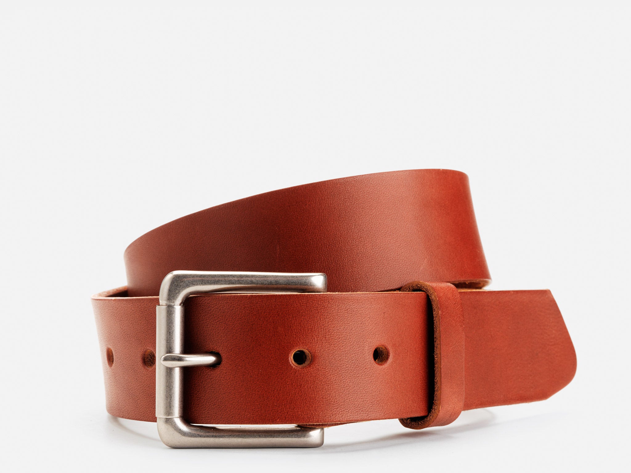 A brown leather belt with a silver rectangular buckle is coiled against a white background. The belt has a smooth texture and three visible holes near the buckle.