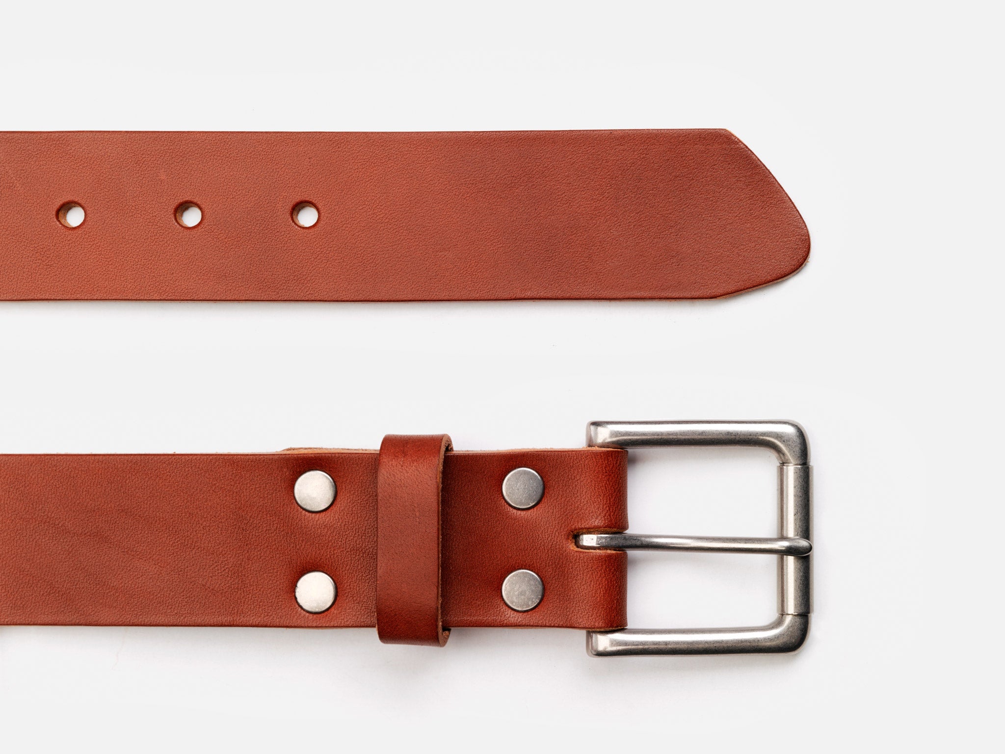A brown leather belt with a silver metal buckle, lying flat on a white background. The belt has several holes and silver rivets near the buckle.