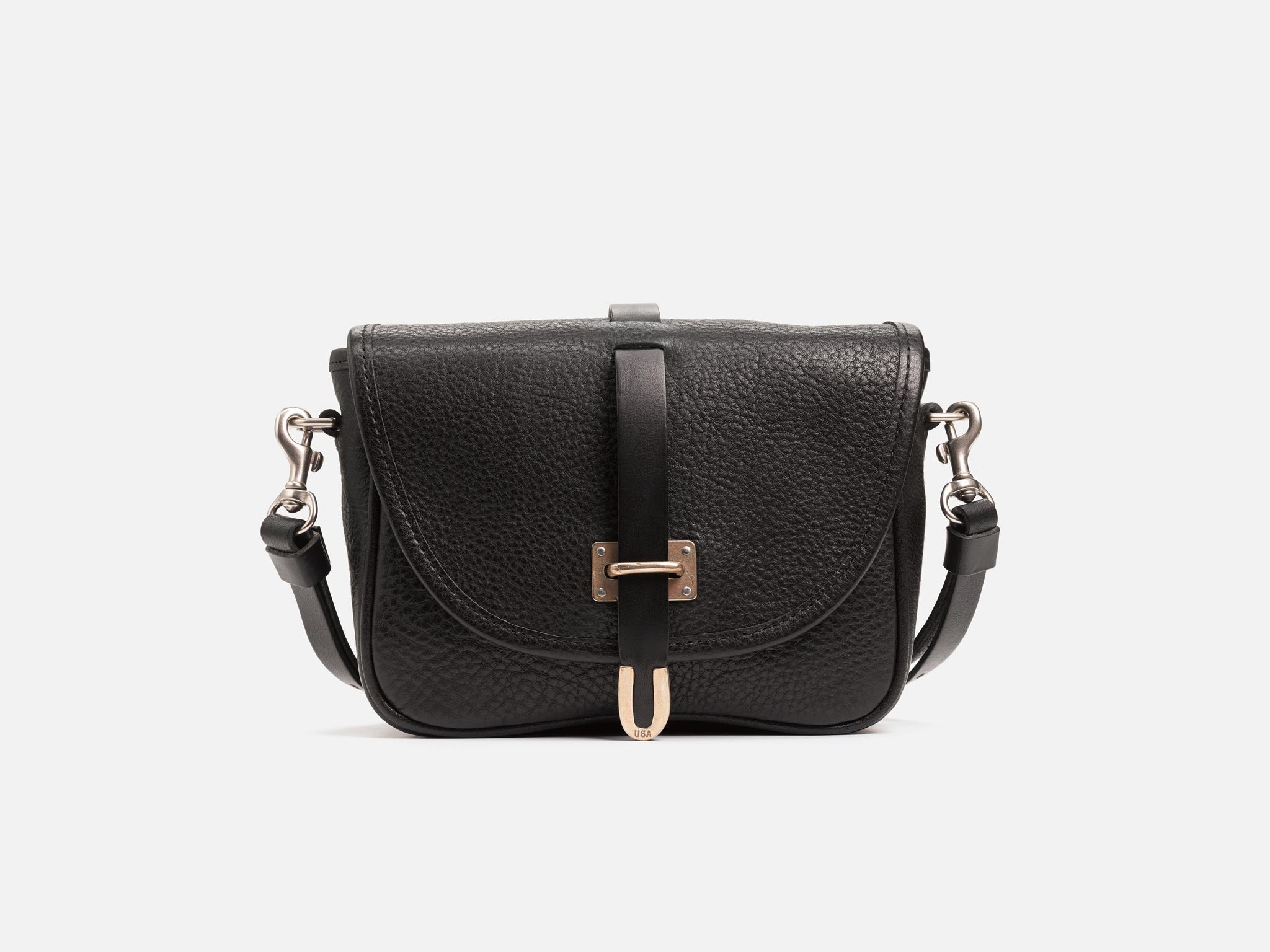 A black leather crossbody bag with a textured finish, front flap, silver hardware, and an adjustable shoulder strap, displayed against a plain white background.