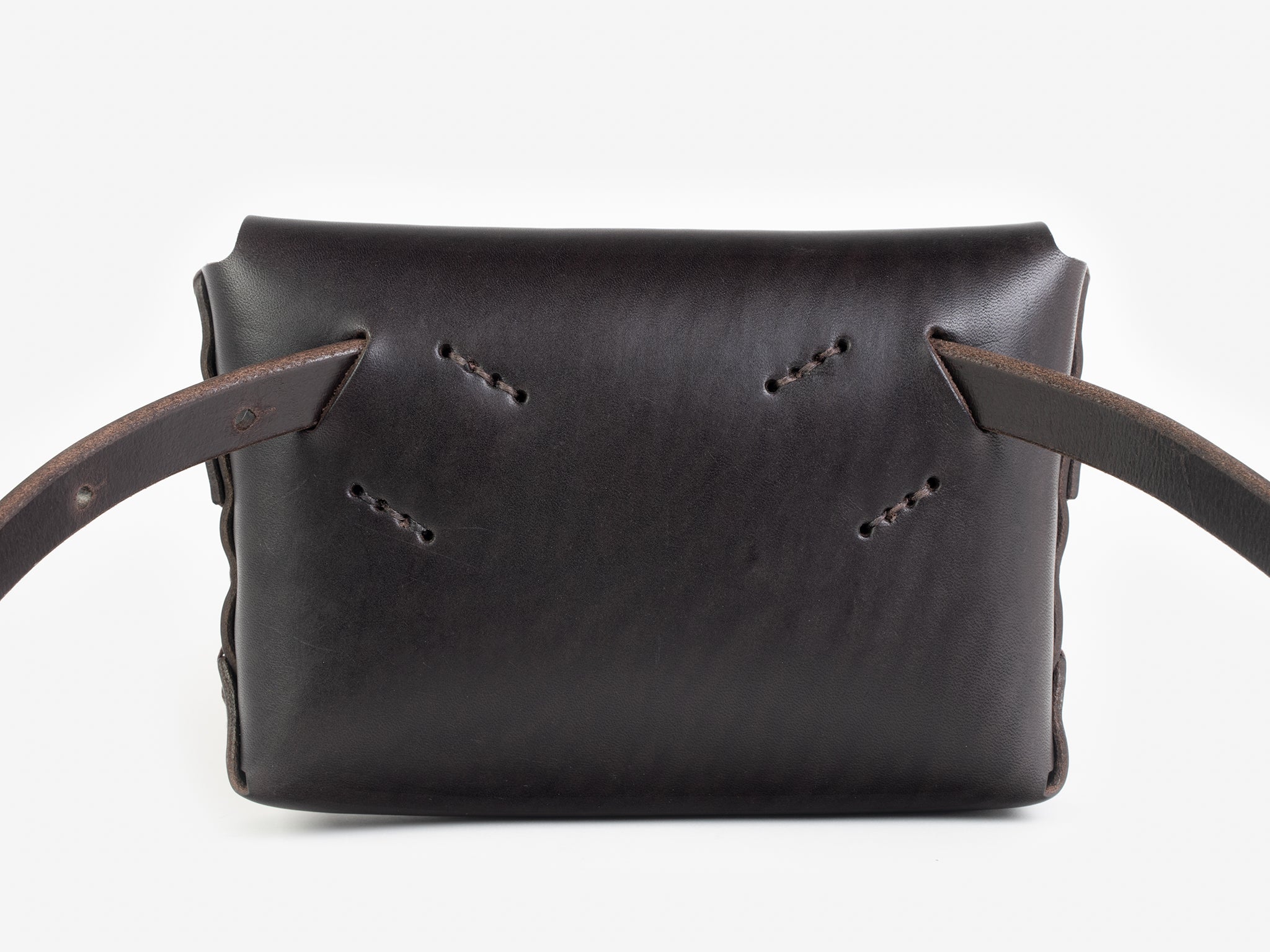 Back view of a dark brown leather belt crossbody bag with a smooth finish, featuring  hand-stitching details, displayed against a white background.