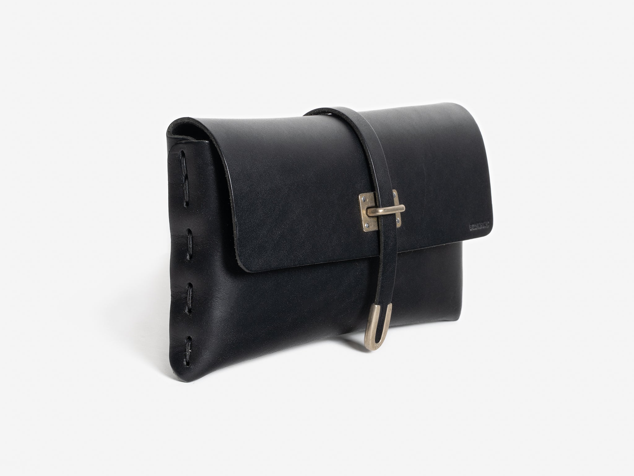 A black leather clutch with a flap closure, side stitching, and a front strap secured by a silver buckle, displayed against a plain white background.