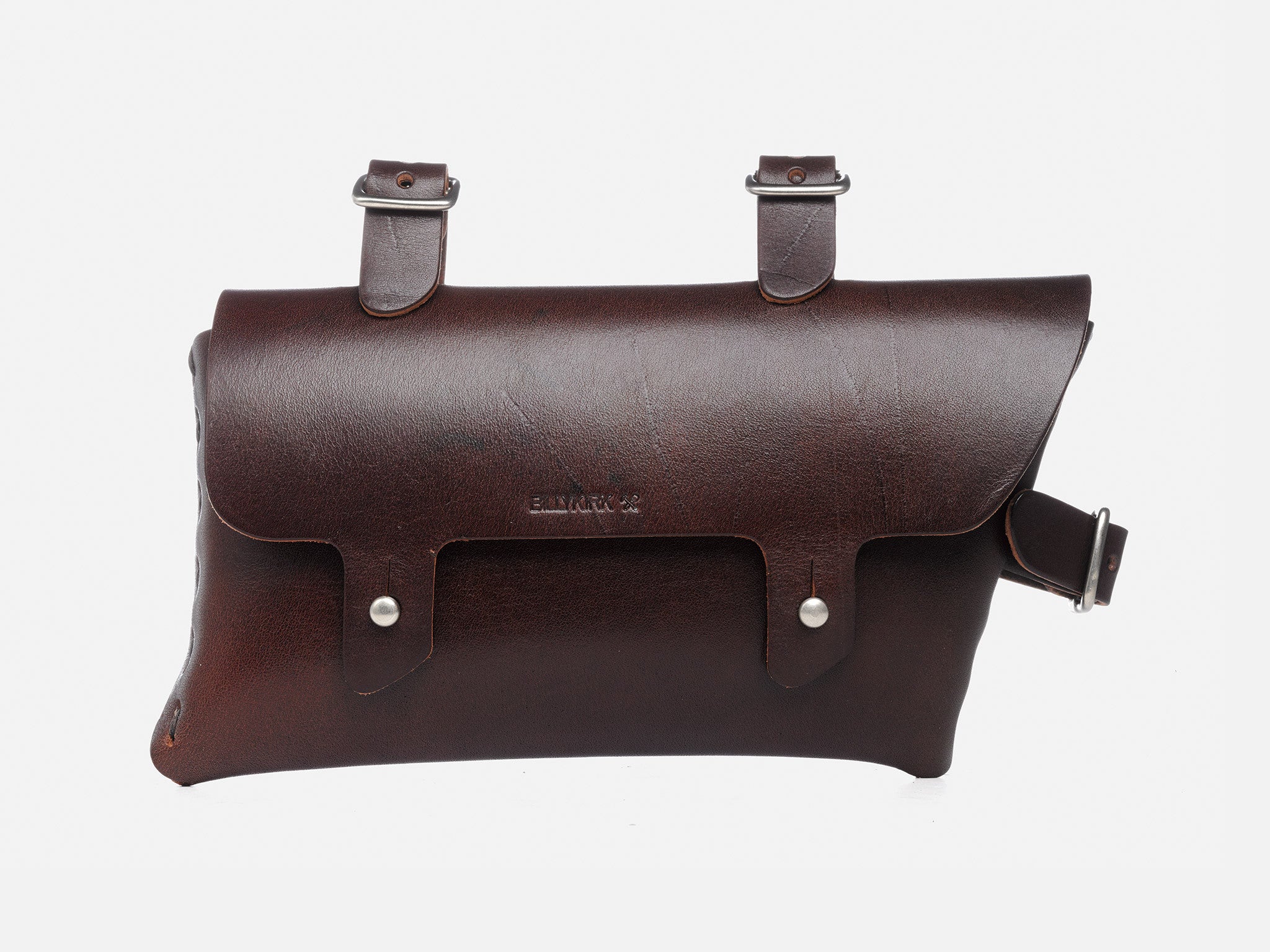 A dark brown leather bicycle saddlebag with two straps and buckles on top for attaching to a bike, and a flap secured by two metal buttons on the front.