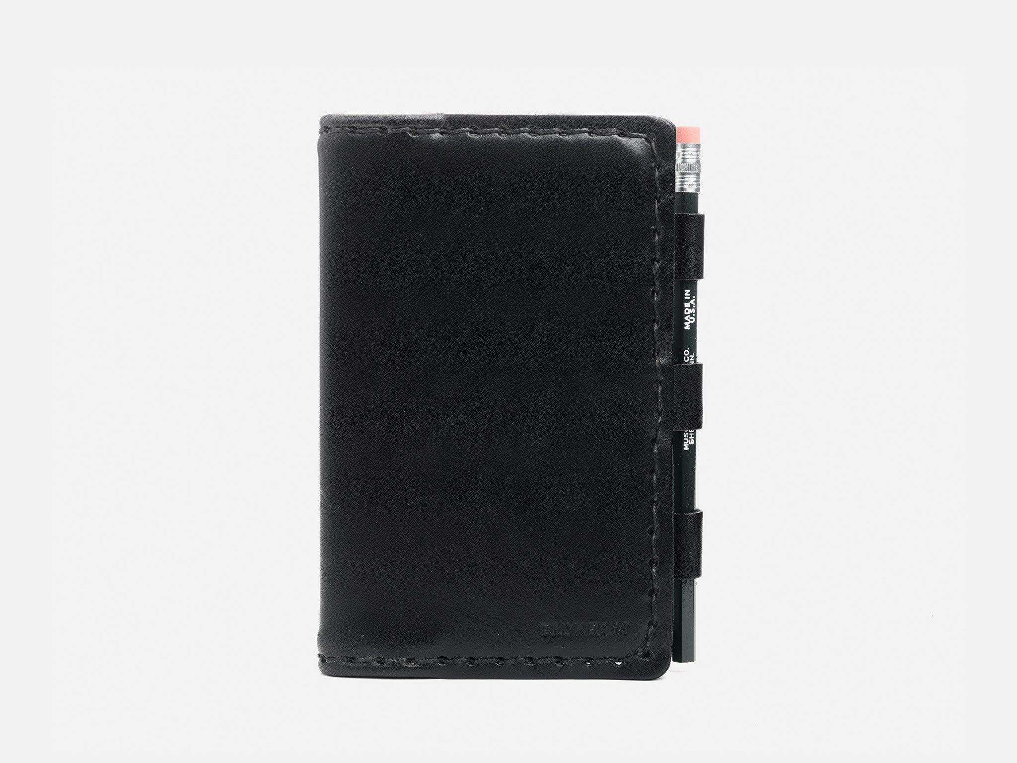 A black leather notebook cover with a pencil held in a side loop, shown against a plain white background.