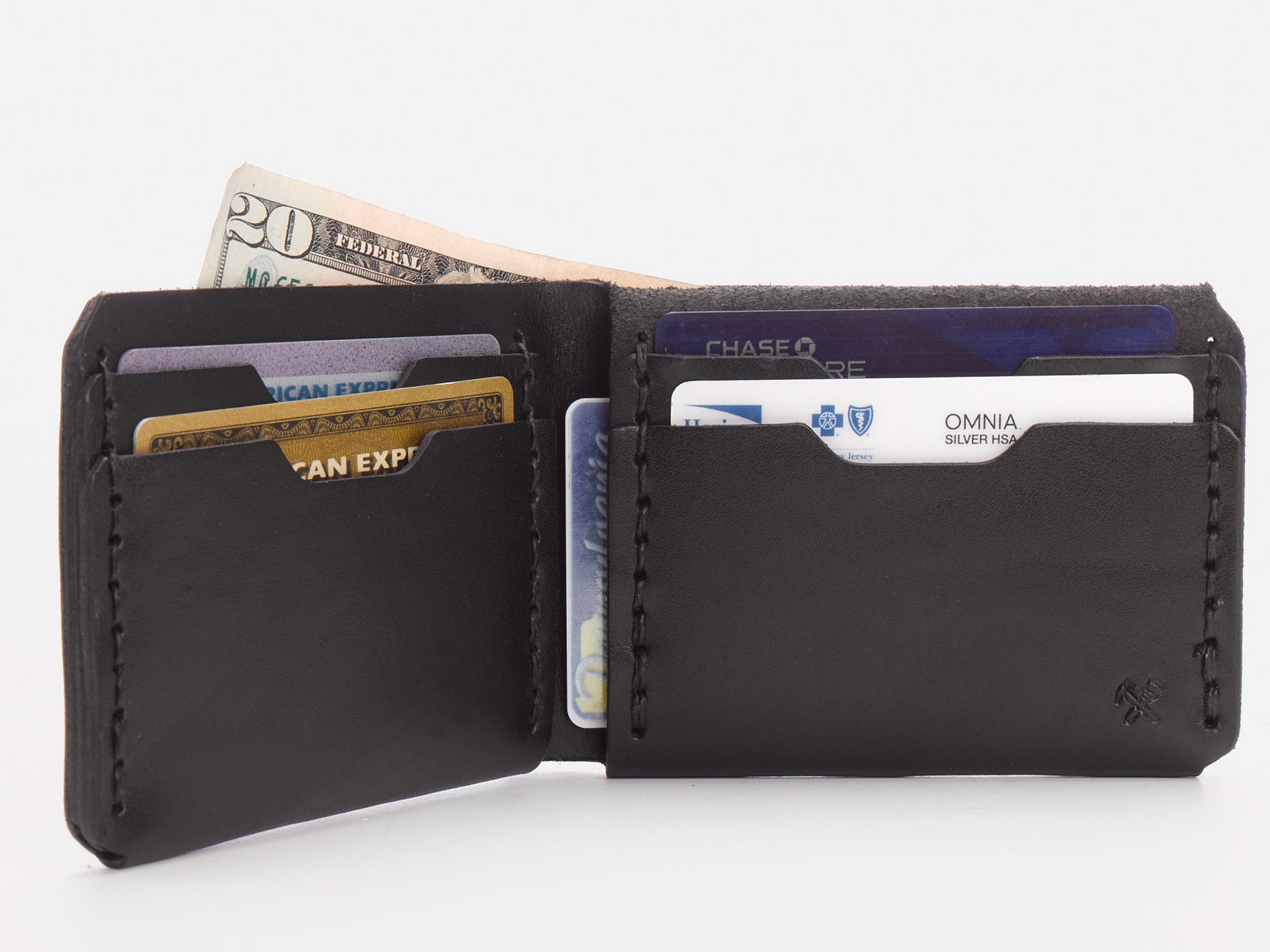 A black leather wallet open to show several credit cards and a few dollar bills partially visible in the cash compartment.