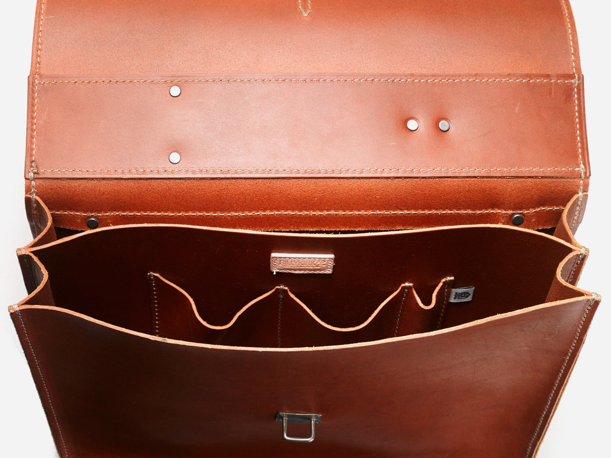 Open tan leather briefcase photographed from above, showing multiple interior compartments and pockets for organization, with stitching detail and metal hardware visible.